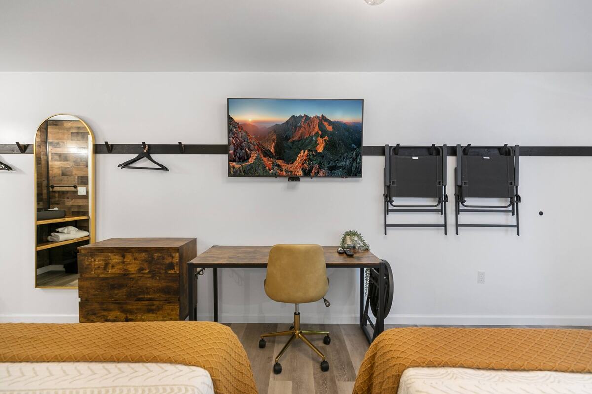 Desk, TV and hanging rail in a remodeled double queen room