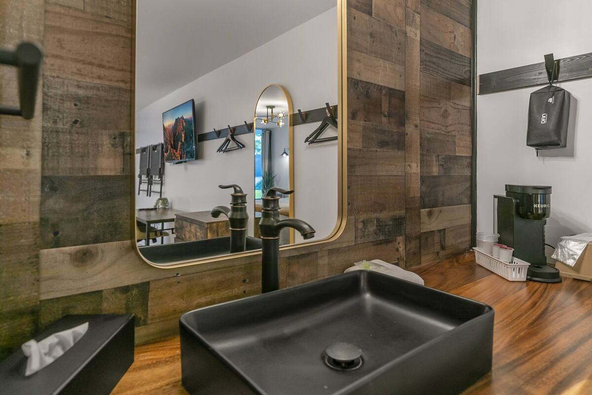 Vanity with a black sink and round mirror